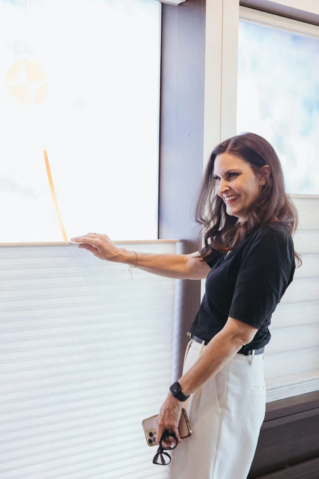 Bridget Mote, owner and lead designer, demonstrating how a window shade opens